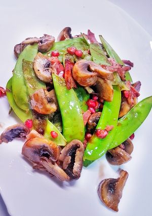 Una foto de Tirabeques salteados en salsa de ostras y granada