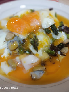 Una foto de Huevos con habitas confitadas, cebolla picante y espárragos