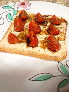Una foto de Tostada con hummus y cherrys