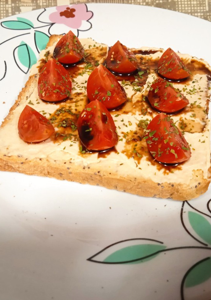 Una foto de Tostada con hummus y cherrys