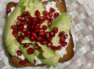 Una foto de Tostada de requesón con granada y aguacate