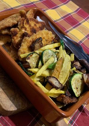 Una foto de Plato variado de patatas, filetes, cebolla crujiente y chips de calabacín