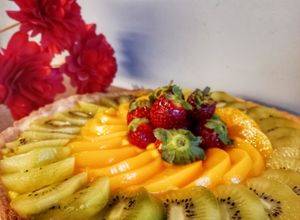 Una foto de Tarta de pastelera, durazno, frutilla y kiwi