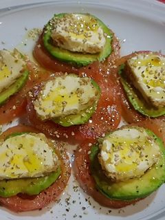 Una foto de Carpaccio de tomate, aguacate y rulo de queso