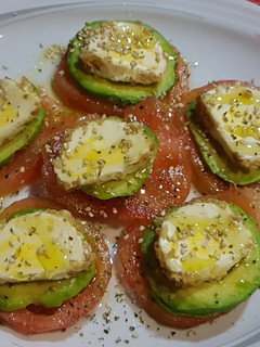 Una foto de Carpaccio de tomate, aguacate y rulo de queso