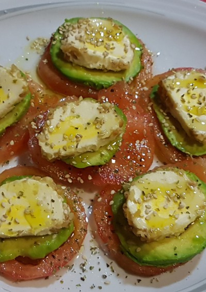 Una foto de Carpaccio de tomate, aguacate y rulo de queso