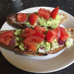 A picture of Avocado and tomato breakfast sandwich.