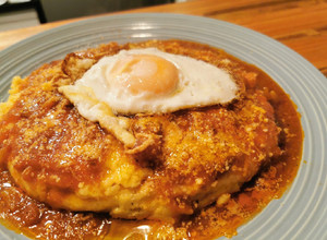 Una foto de Polenta con tuco de pollo y huevo frito