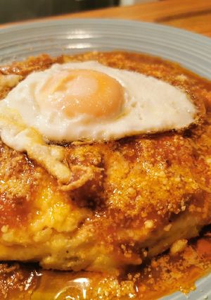 Una foto de Polenta con tuco de pollo y huevo frito