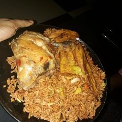 A picture of Jollof rice with chicken and fried plantain.
