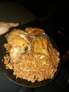 A picture of Jollof rice with chicken and fried plantain.
