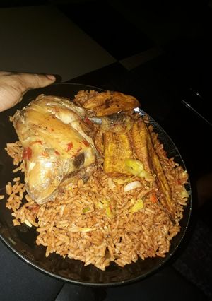 A picture of Jollof rice with chicken and fried plantain.