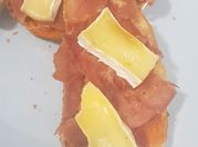 Una foto de queso brie y jamón serrano