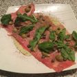 Carpaccio con aceitunas y rúcula