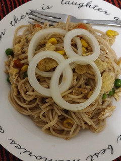 A picture of Noodles with some veggies and egg.