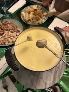 Una foto de Fondue de quesos con cerdo y pollo a taquitos