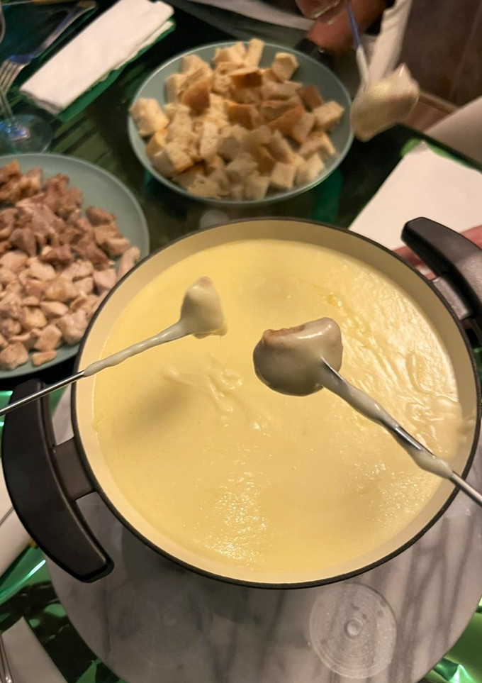 Una foto de Fondue de quesos con cerdo y pollo a taquitos