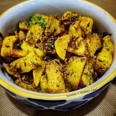 A picture of Baked potato wedges with cumin and garlic tempering.