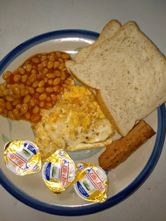 A picture of Oyibo breakfast (fried egg,bread, baked beans, sausage).