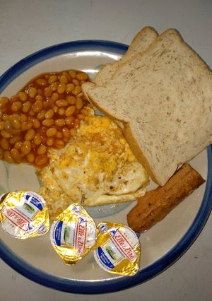 A picture of Oyibo breakfast (fried egg,bread, baked beans, sausage).