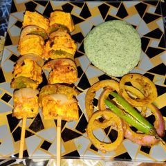 A picture of Achari paneer tikka with achari onion rings.