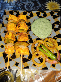 A picture of Achari paneer tikka with achari onion rings.
