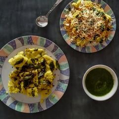 A picture of Gujarati dhokla, cheese Surti locho with green chutney.