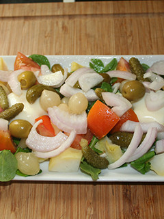 Una foto de Ensalada de canónigos, rúcula y encurtidos