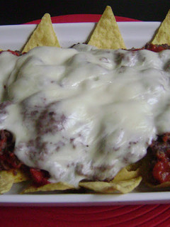 Una foto de Nachos con frijoles refritos y queso