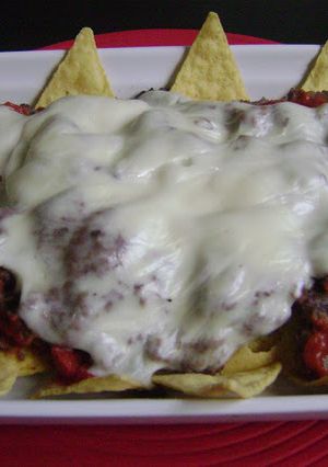 A picture of Nachos with Refried Beans and Cheese.