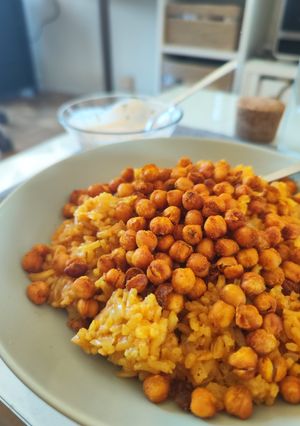 Una foto de Arroz al curry con garbanzos crujientes y salsa de yogurt
