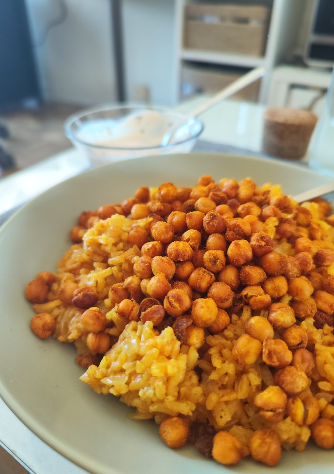 Una foto de Arroz al curry con garbanzos crujientes y salsa de yogurt