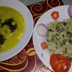 A picture of Punjabi kadhi with green peas and coriander rice.