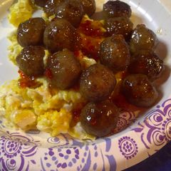 A picture of Spicy meatballs over eggs.