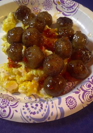 A picture of Spicy meatballs over eggs.