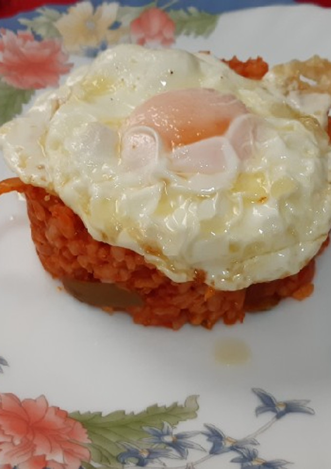 Una foto de Huevo frito con arroz con tomate y verduras
