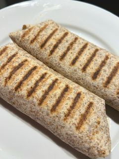 Una foto de Wrap de tofu, cebolla caramelizada y champiñones al horno con guacamole y salsa verde