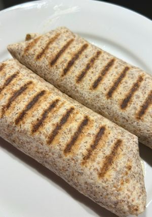 Una foto de Wrap de tofu, cebolla caramelizada y champiñones al horno con guacamole y salsa verde