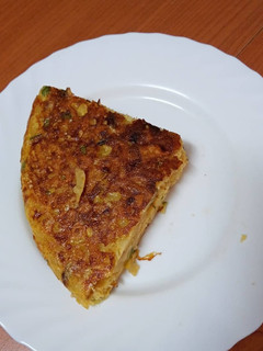 Una foto de Tortilla de papas, calabacín, cebolla y chistorra