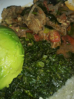 A picture of Beef stew served with ugali and saute kale.