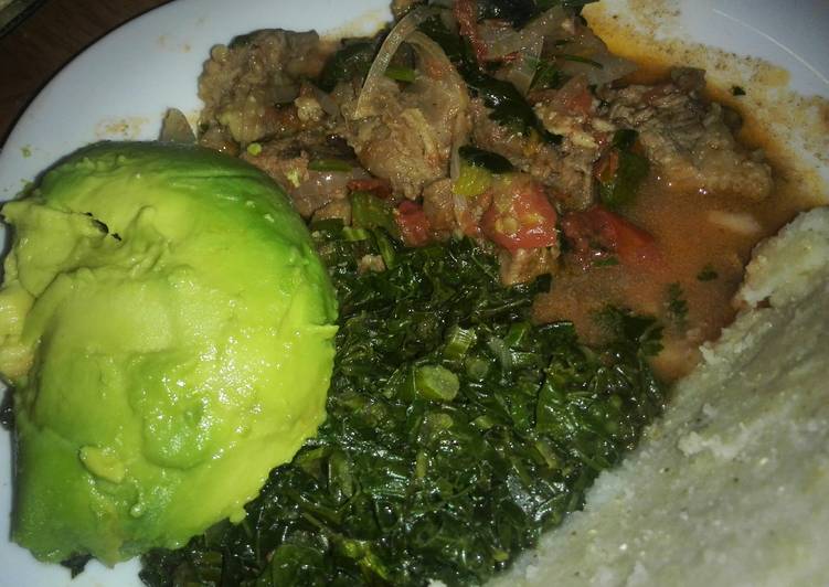 Beef stew served with ugali and saute kale
