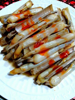 Una foto de Navajas a la plancha con escamas de sal al limón y salsa thai
