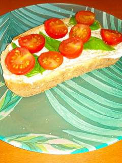 Una foto de Tostada de queso crema, cherrys y albahaca