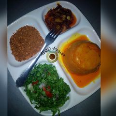 A picture of Moi moi with palm oil sauce and lettuce.