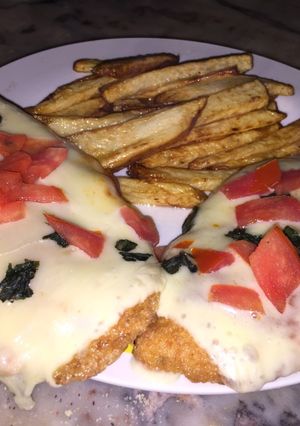 Una foto de Milanesa a la caprese con papas fritas rústicas
