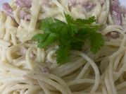 Una foto de pasta con crema de leche y tocineta