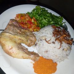 A picture of Rice and beans with chicken and salad.
