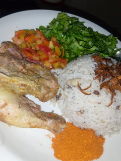 A picture of Rice and beans with chicken and salad.