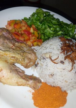 A picture of Rice and beans with chicken and salad.