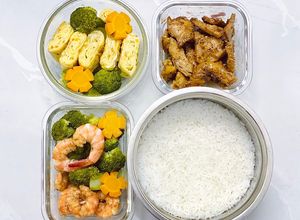 Hình của món Cơm trứng cuộn, tôm áp chảo, bông cải luộc, gà xào.